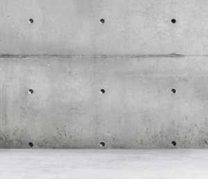 Betonwand mit gleichmaessigen Oeffnungen – Symbolbild fuer schallisolierten Aufbau in akustischer Testumgebung