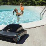 Poolroboter am Beckenrand mit spielender Mutter und Kind im Wasser – Symbolbild fuer komfortable und sichere Poolpflege im Familienalltag