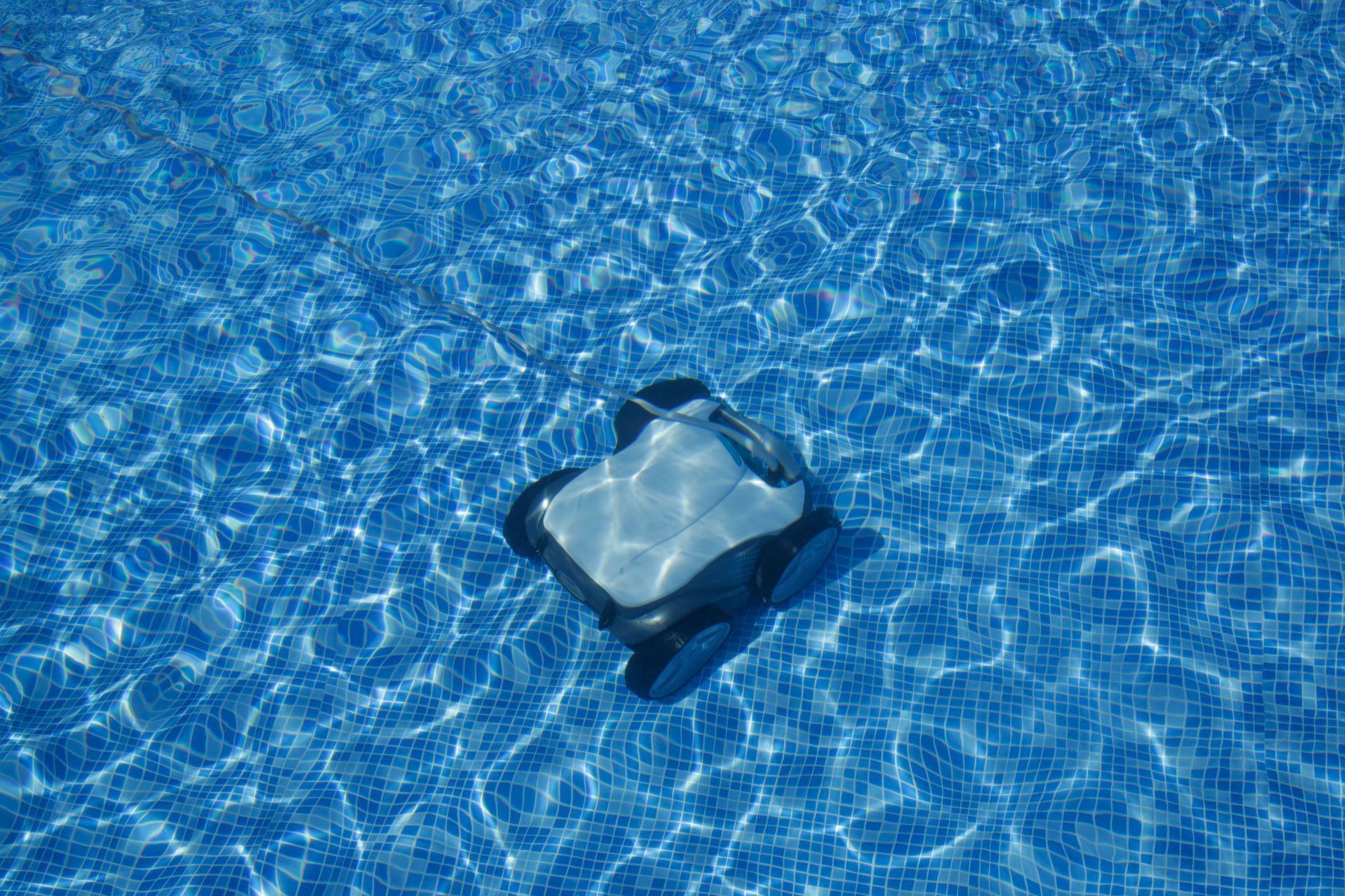 Poolroboter im Einsatz auf Poolboden mit blauen Mosaikfliesen – effektive Reinigungstechnologie sichtbar im Wasser