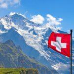 Spenden Schweiz vor alpiner Kulisse mit Schweizer Flagge und Bergen im Hintergrund