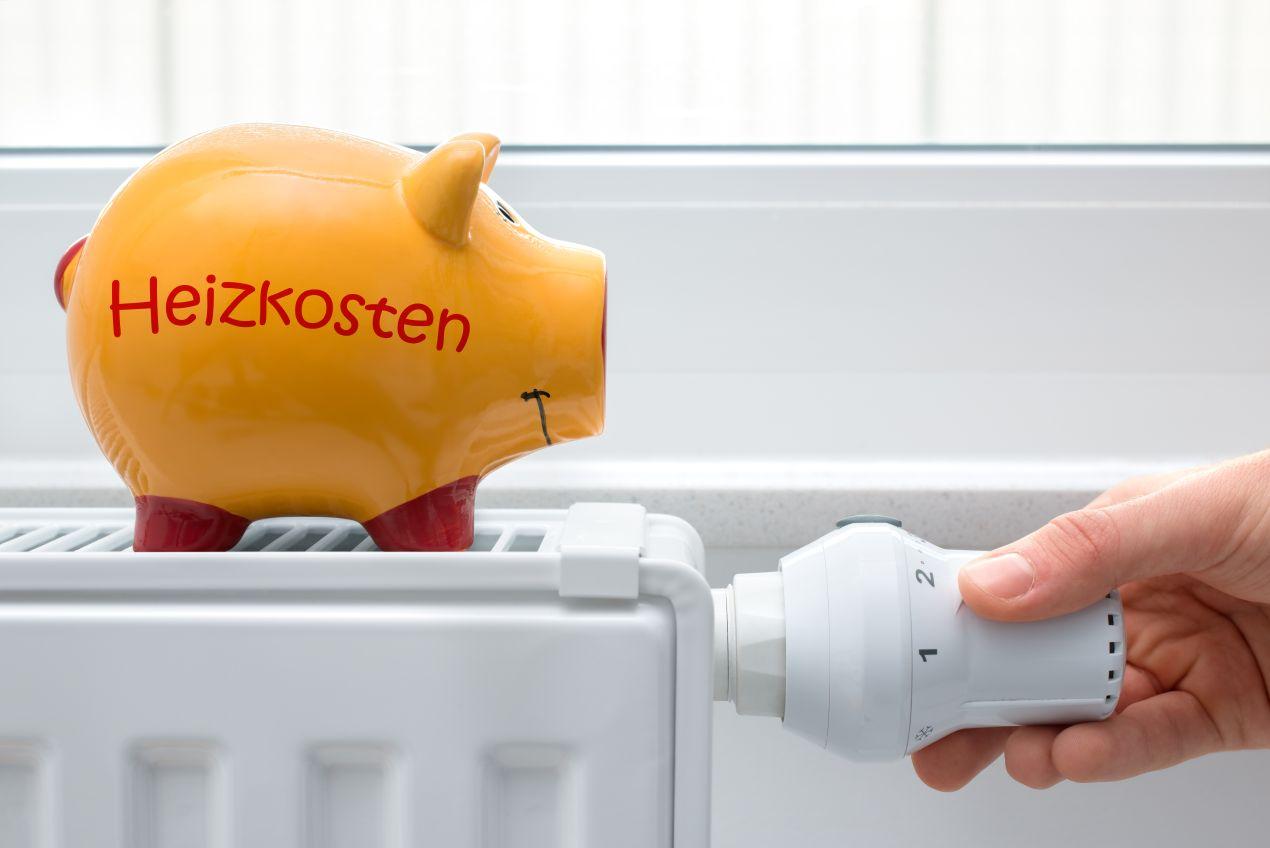 Sparschwein mit Schriftzug Heizkosten auf Heizung – Symbol fuer steigende Heizölpreise Krefeld und Spartipps