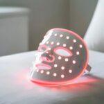 LED-Maske mit rotem Licht auf Liege | Haarentfernung Düsseldorf